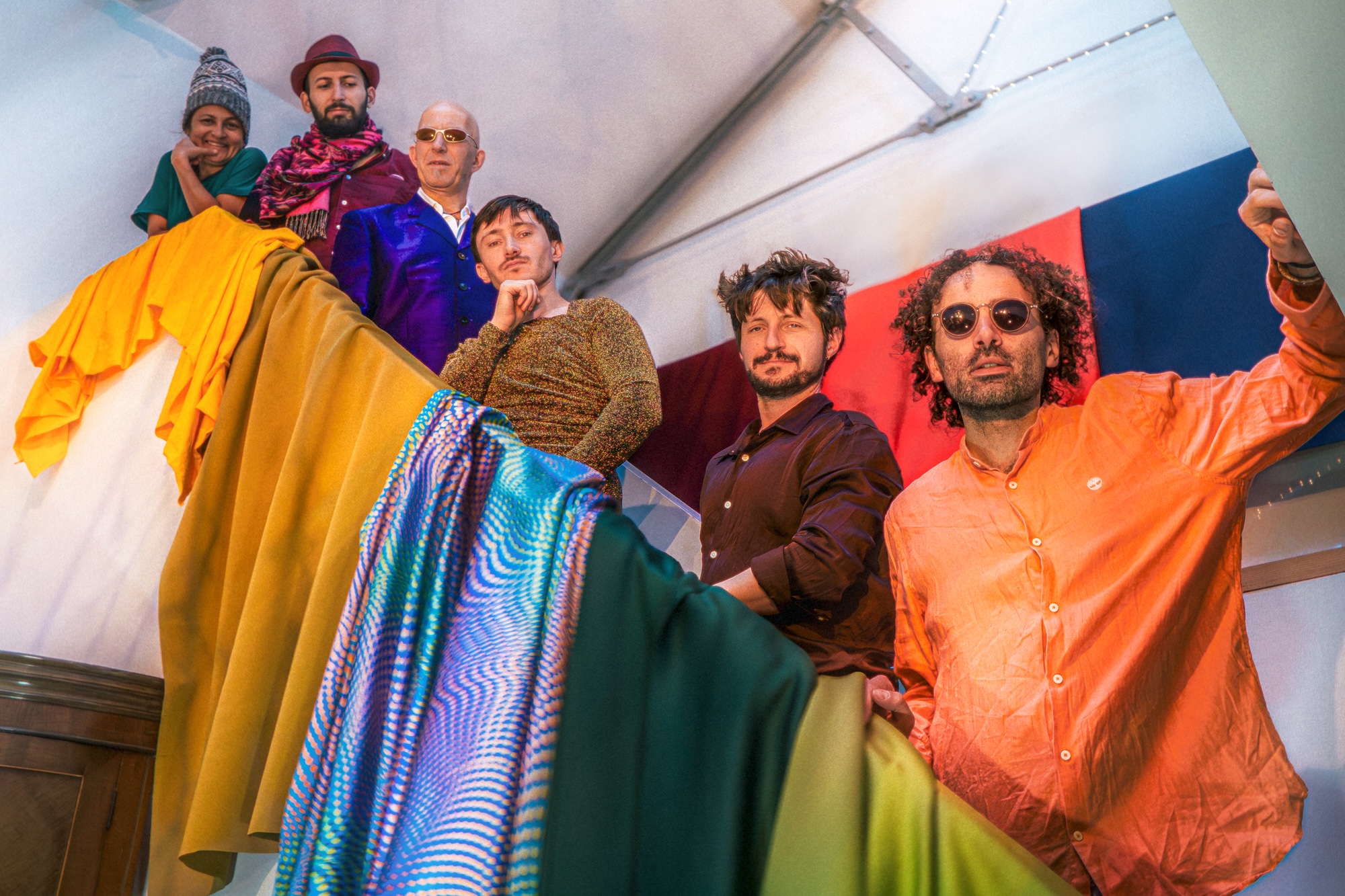 Vientos 7-piece band performing live with Latin folk rock music, featuring vocals, guitar, bass, violin, saxophone, percussion, and keyboards